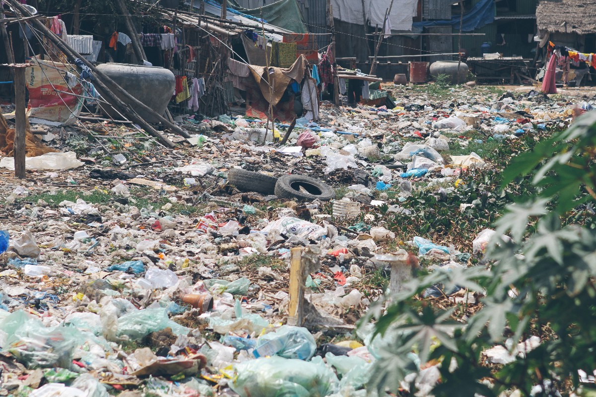 Piles of trash including tires, plastic bags, disregarded containers and more sit alongside homes in Andong.